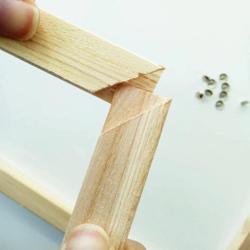Bastidor de madera para pinturas por números, mostrando esquinas unidas y tornillos en el fondo.